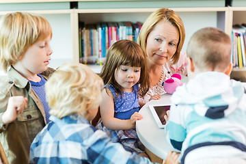 Image showing Teacher With Students Using Digital Tablet In Library