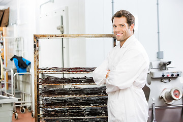 Image showing Confident Worker Standing By Rack Of Beef Jerky At Shop