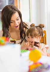 Image showing Mother Looking At Girl Eating Cupcake