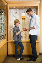 Image showing Optometrist And Boy Holding Spectacles In Store