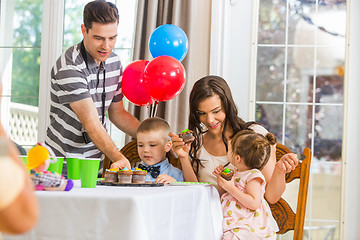 Image showing Family Eating Cupcakes At Birthday Party