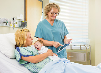 Image showing Nurse Explaining Reports On Digital Tablet To Woman With Babygir