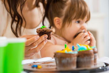 Image showing Mother Holding Cupcake With Girl Eating Cake