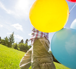 Image showing Boy With Balloons Walking In Meadow