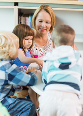 Image showing Teacher And Students At Table In Library