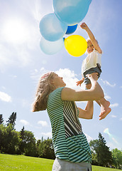 Image showing Mother And Daughter Playing With Balloons In Park