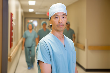 Image showing Confident Doctor With Team Walking In Corridor