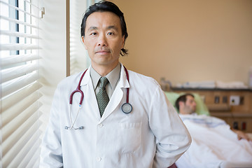 Image showing Confident Doctor With Patient In Background At Hospital Room