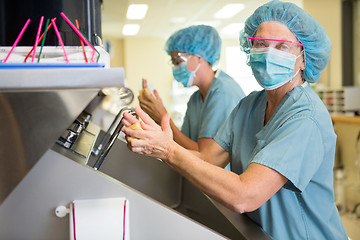 Image showing Doctor Scrubbing Hands With Colleague