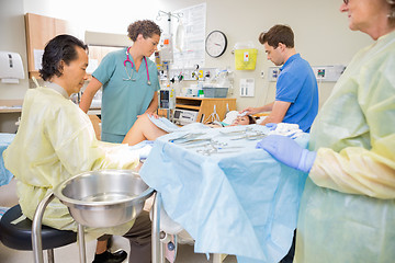 Image showing Doctor Operating Pregnant Woman During Delivery With Man And Nur