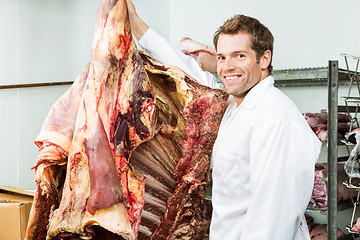 Image showing Butcher Standing Beside Beef in Cooler