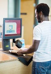 Image showing Librarian Scanning Books At Bookstore Counter