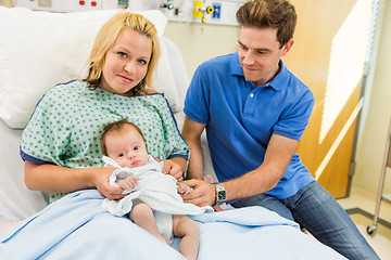 Image showing Woman With Newborn Baby Girl Sitting By Man In Hospital