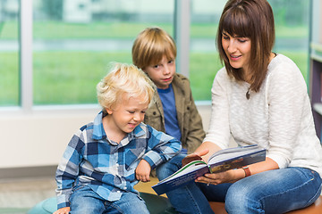 Image showing Teacher With Schoolboys Reading Book In Library