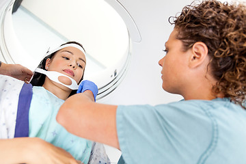 Image showing Patient Looking At Nurse Adjusting Strap Before CT Scan