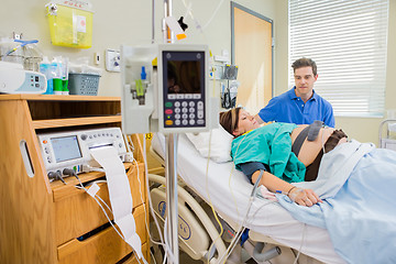 Image showing Man Looking At Pregnant Wife Lying On Hospital Bed