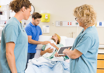 Image showing Nurses Discussing Report On Digital Tablet Against Couple With B