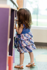 Image showing Girl Selecting Book From Bookshelf