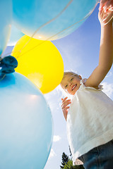 Image showing Happy Girl Holding Balloons Against Sky