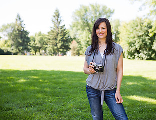 Image showing Attractive Woman Holding Digital Camera In Park