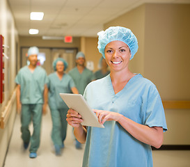 Image showing Doctor With Digital Tablet While Team Walking In Hospital Corrid