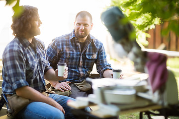 Image showing Carpenter With Coworker Holding Disposable Coffee Cup At Site