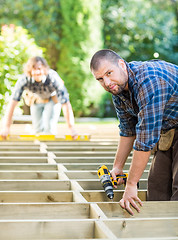 Image showing Carpenter Holding Drill At Construction Site