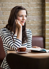 Image showing Woman With Hand On Chin Looking Away In Coffeeshop