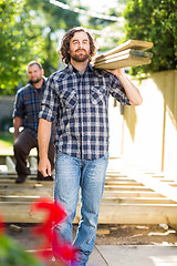 Image showing Carpenters Carrying Wooden Planks