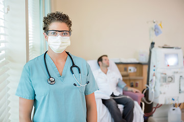 Image showing Nurse In Protective Clothing While Patient Receiving Dialysis