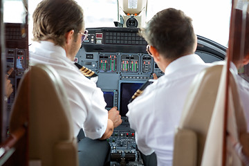 Image showing Pilots Operating Controls Of Corporate Jet