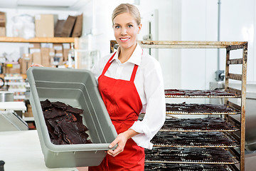 Image showing Worker Showing Beef Jerky In Basket At Shop