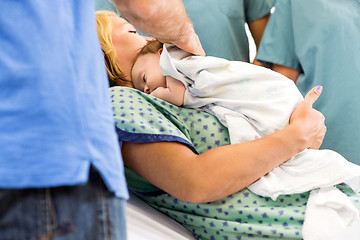 Image showing Babygirl Lying On Mother Surrounded By Nurses And Father