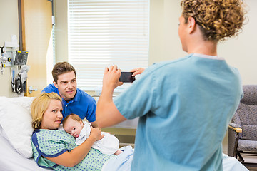 Image showing Nurse Photographing Couple With Newborn Baby Through Cellphone