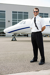 Image showing Confident Pilot With Private Jet In Background