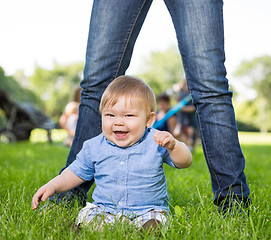 Image showing Cute Baby Boy Sitting In Front Of Mother In Park