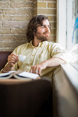 Image showing Man With Coffee Cup Looking Through Window In Cafe