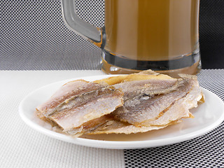 Image showing smoked fish and cup of beer on a background