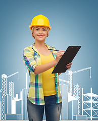 Image showing smiling woman in helmet with clipboard