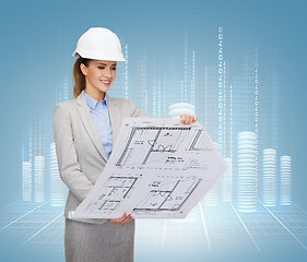 Image showing smiling architect in white helmet with blueprints