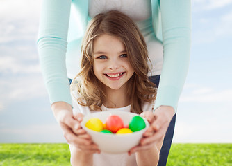 Image showing smiling girl and mother holding colored eggs