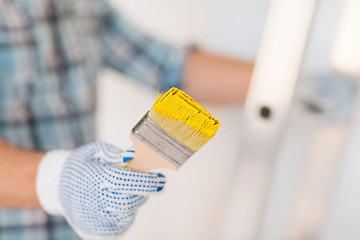 Image showing close up of male in gloves holding paintbrush