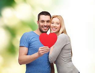 Image showing smiling couple holding big red heart