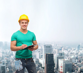 Image showing smiling man in helmet with clipboard