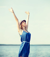 Image showing girl with hands up on the beach