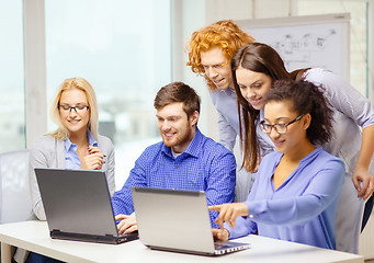 Image showing smiling team with laptop computers in office