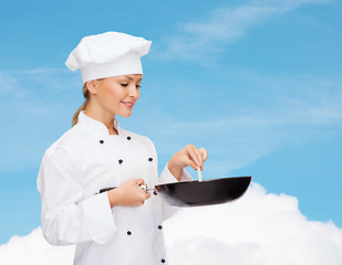 Image showing smiling female chef with pan and spoon