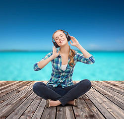 Image showing young woman listeting to music with headphones