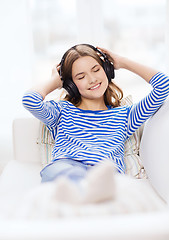 Image showing smiling young girl in headphones at home