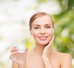 Image showing woman applying cream on her skin